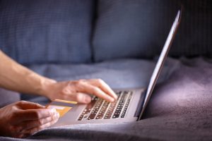 Man holding a credit card, shopping online after the store’s new e-commerce growth strategies